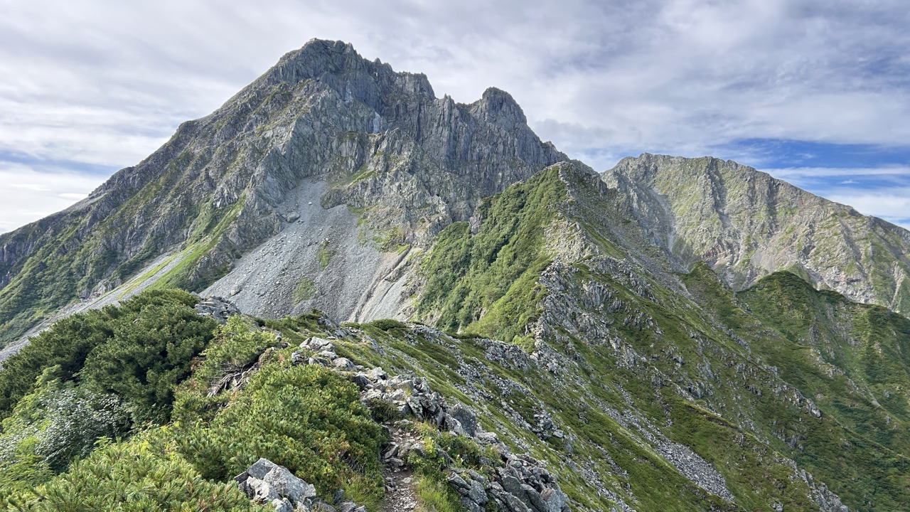 大キレットの岩稜へ続く登山道と、正面にそびえる岩壁の全景