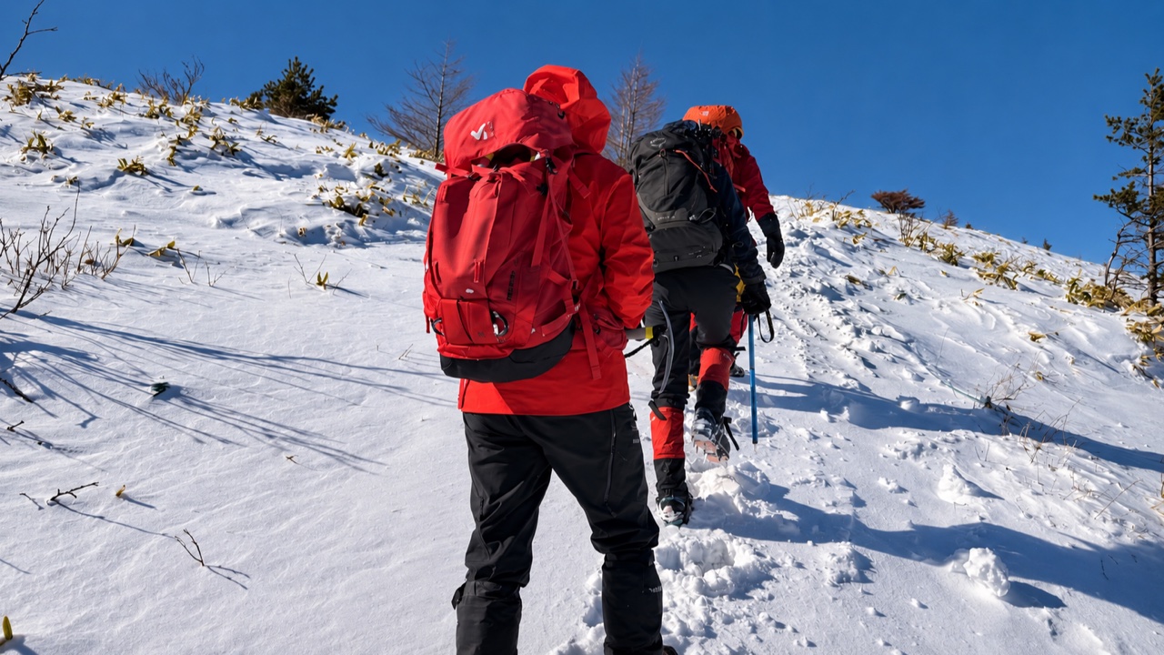 湯ノ丸山の雪の斜面を登る参加者